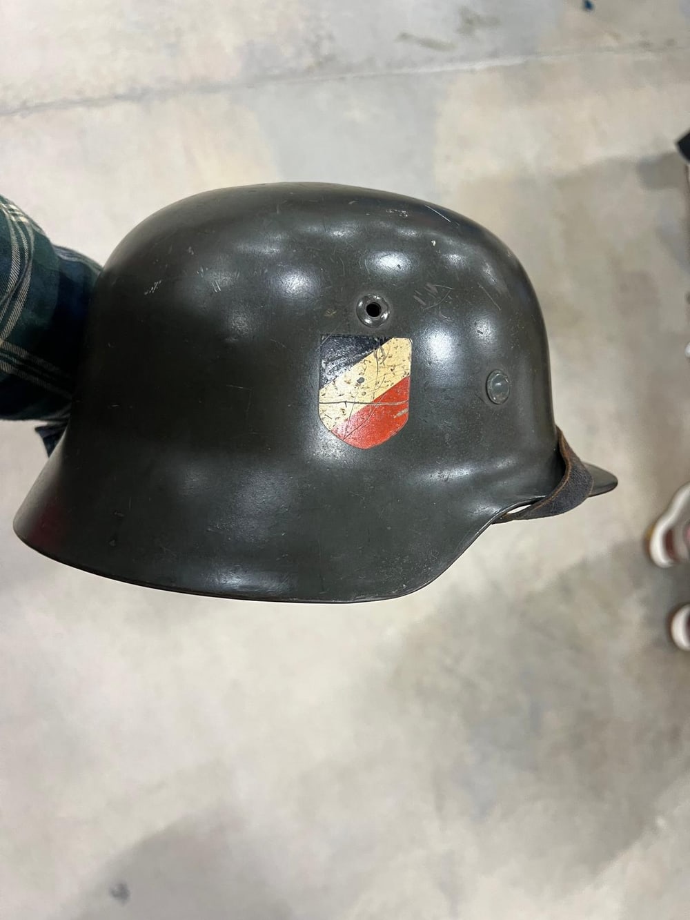 Casco alemán de la Segunda Guerra Mundial, completo y con las dos calcomanías: en este lado, el escudo tricolor.