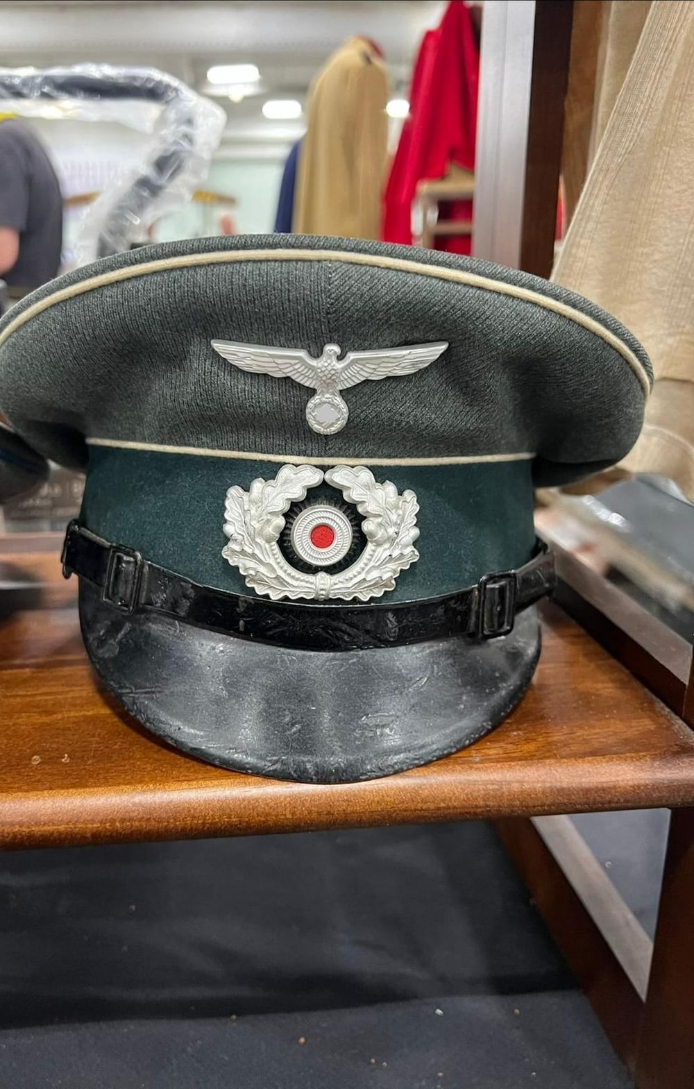 Gorra de visera (Schirmmütze) del Heer, de infantería por el vivo blanco, con corona de roble y escarapela. El símbolo del águila va tapado (§ 86a StGB).