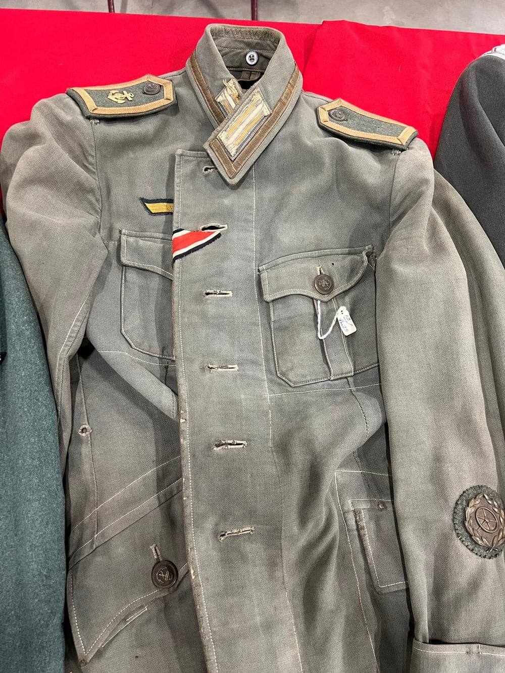 Guerrera gris de campaña de la Kriegsmarine: hombreras con el ancla, cinta de la Cruz de Hierro en el ojal y distintivo de conductor en la manga.
