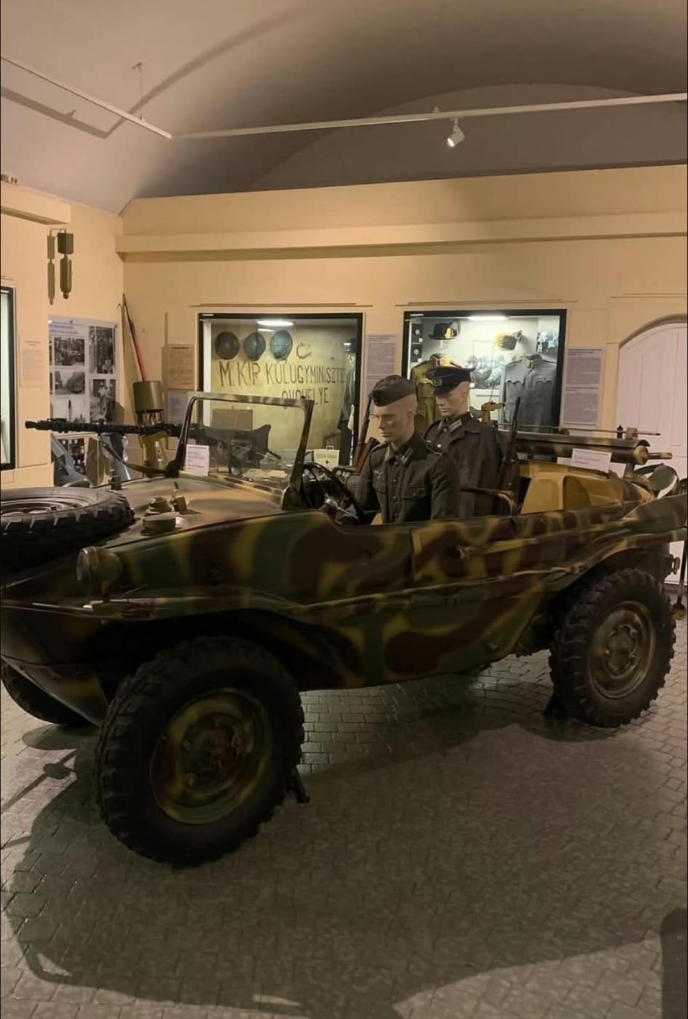 Schwimmwagen con pintura de camuflaje, la rueda de repuesto sobre el capó y el soporte de ametralladora.